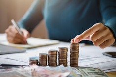 Деловая женщина держит монеты в руках, чтобы сложить их на столе, концепция экономии денег, финансов и бухгалтерского учета